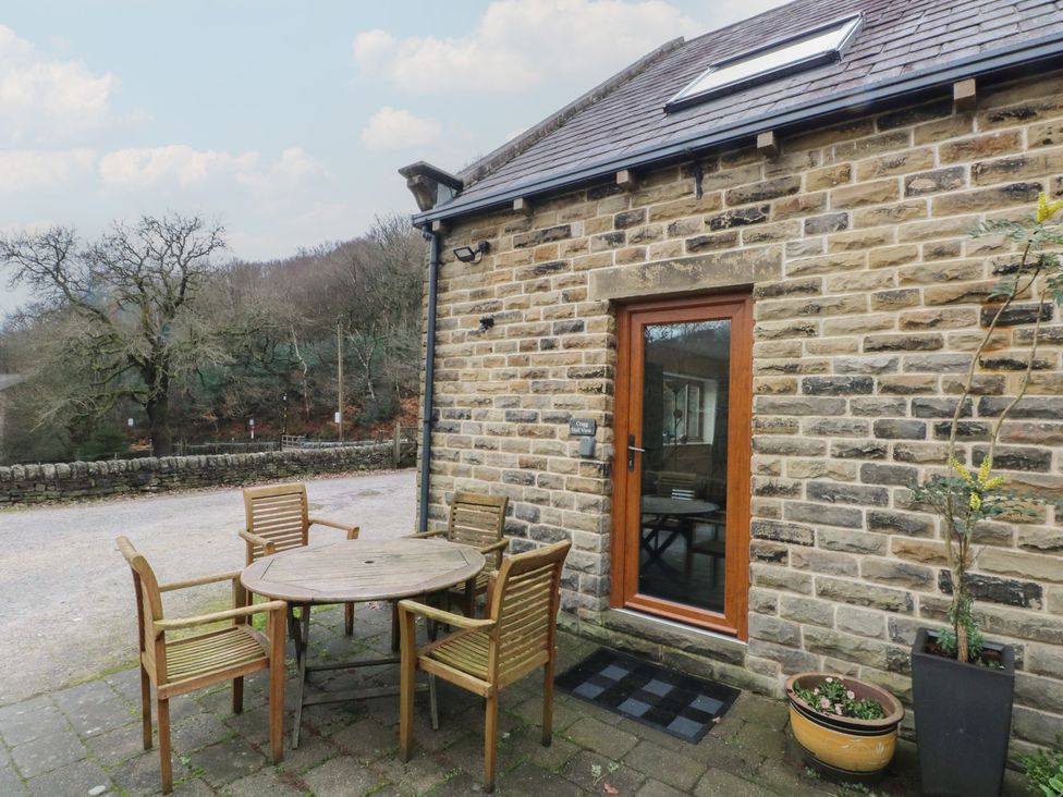 An outdoor seating area with a table and chairs at Cragg Hall View in Cragg Vale