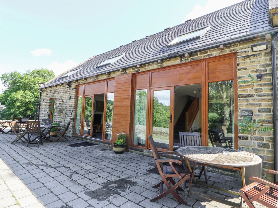 An outdoor area with a patio, table, and chairs at Cragg Hall View in Cragg Vale