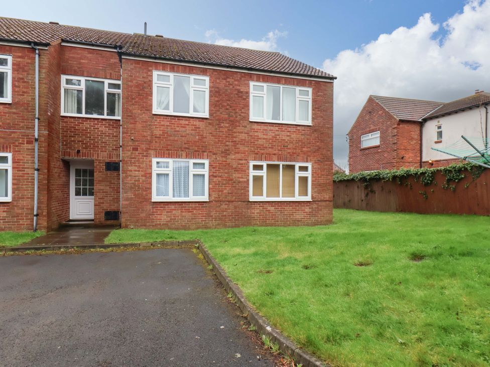 A brick house with a front door and grass in the outdoor area at Flat 1, 40 Hinderwell Lane