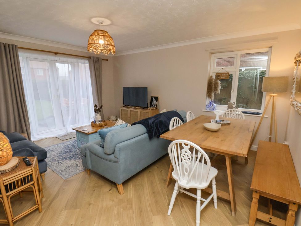 A living room with a sofa, table, and television at Flat 1, 40 Hinderwell Lane