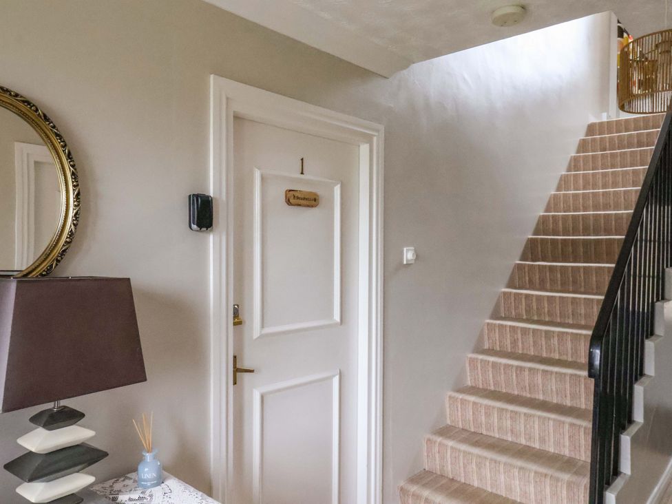 A hallway with stairs and a door at Flat 1, 40 Hinderwell Lane