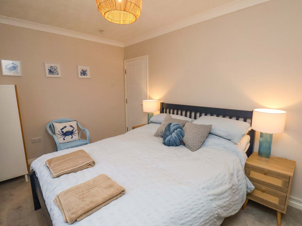 A bedroom with a bed and side table at Flat 1, 40 Hinderwell Lane