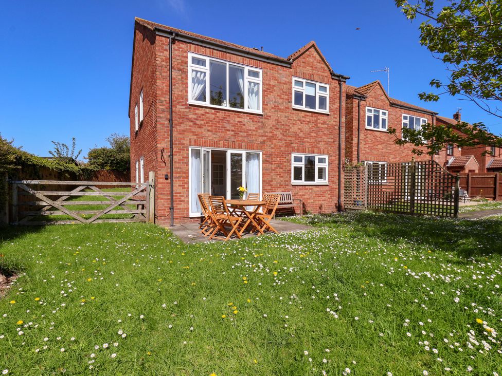 A garden with a table and chairs at Seashells at Runswick Lodge Runswick Bay