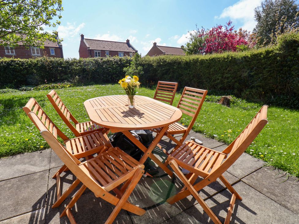 A patio table with chairs and flowers in a vase at Seashells at Runswick Lodge Runswick Bay