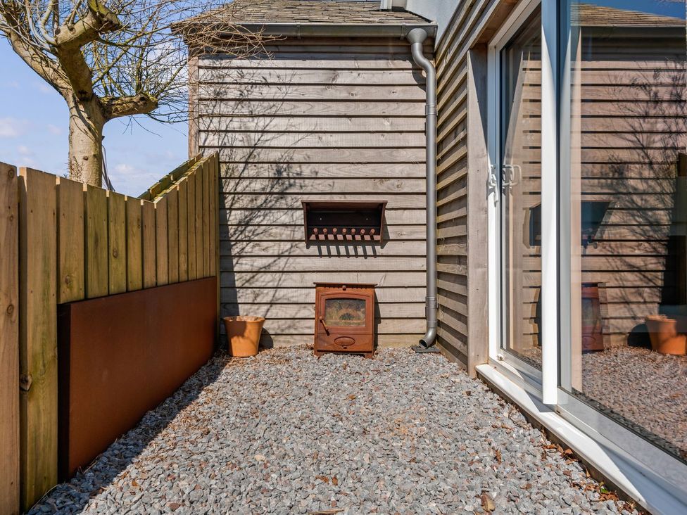 A garden area with gravel and an outdoor heater at Capton Snug Dartmouth