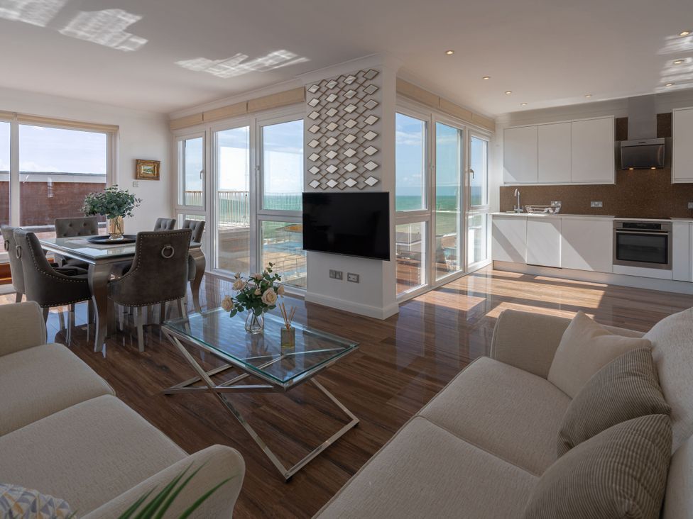 A living room with a dining area and kitchen at the Beachfront Penthouse in Brighton