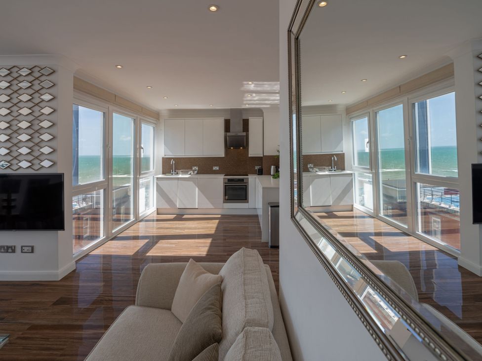 A living room with a kitchen and ocean view at Beachfront Penthouse in Brighton