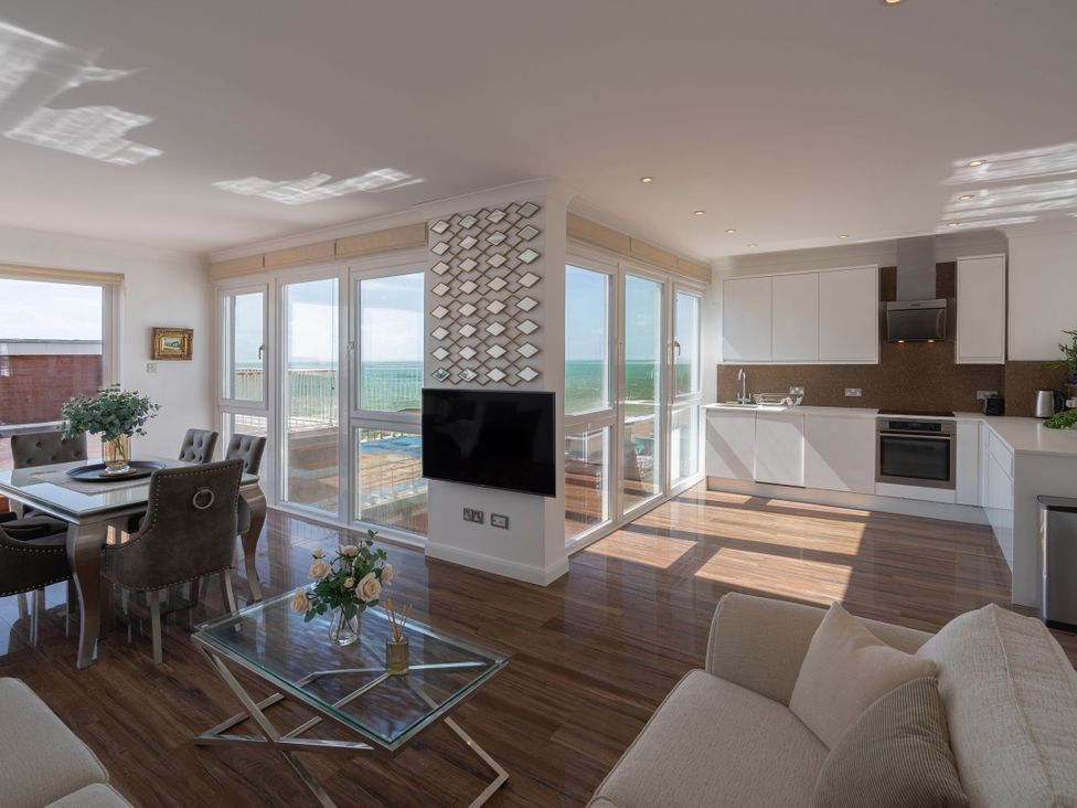 A living room with a dining area and kitchen at Beachfront Penthouse in Brighton