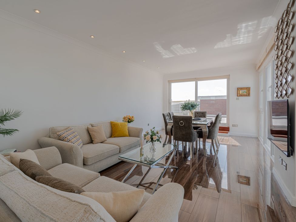 A living room featuring a sofa and dining table at Beachfront Penthouse in Brighton