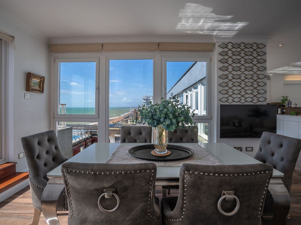 A dining area with a view of the sea at Beachfront Penthouse in Brighton