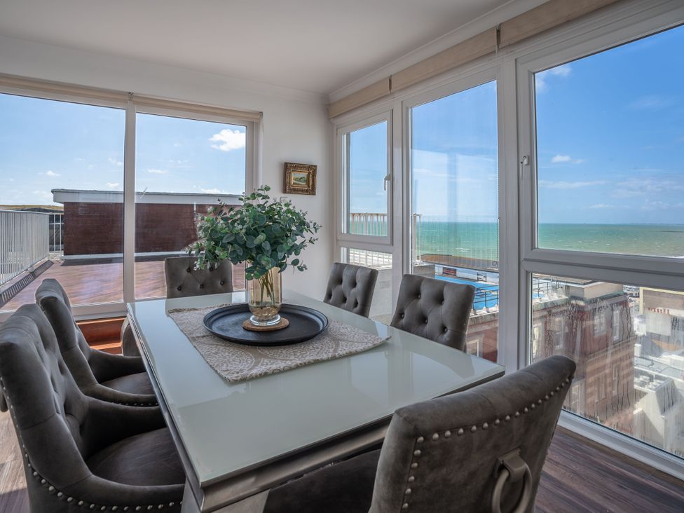 A dining room with a table and chairs at Beachfront Penthouse in Brighton