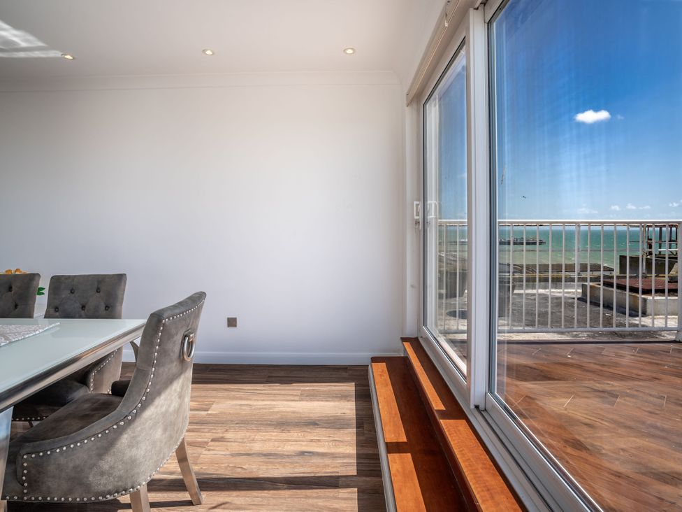 A dining room with a table and chairs at Beachfront Penthouse Brighton