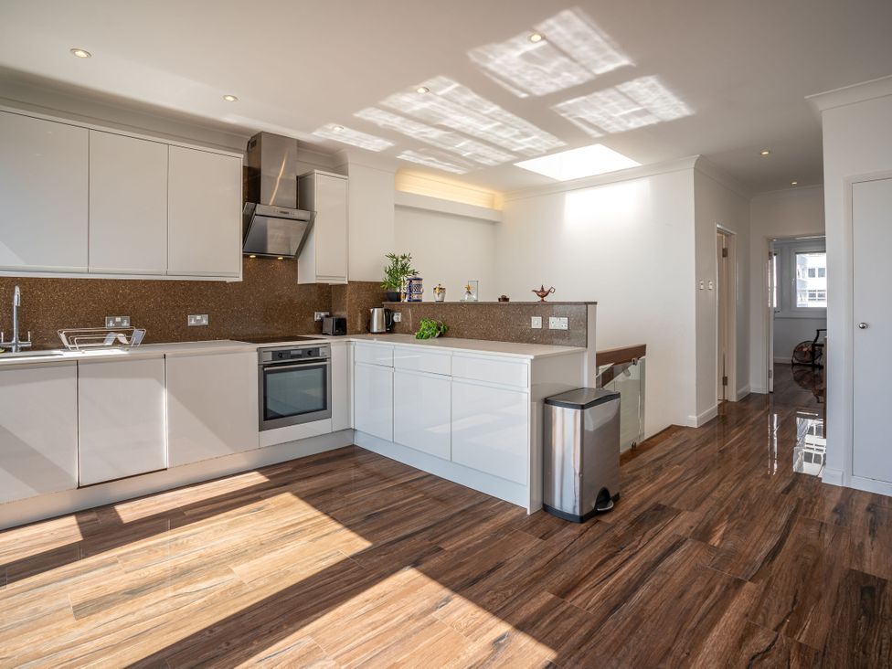 A modern kitchen with cabinets and appliances at Beachfront Penthouse in Brighton