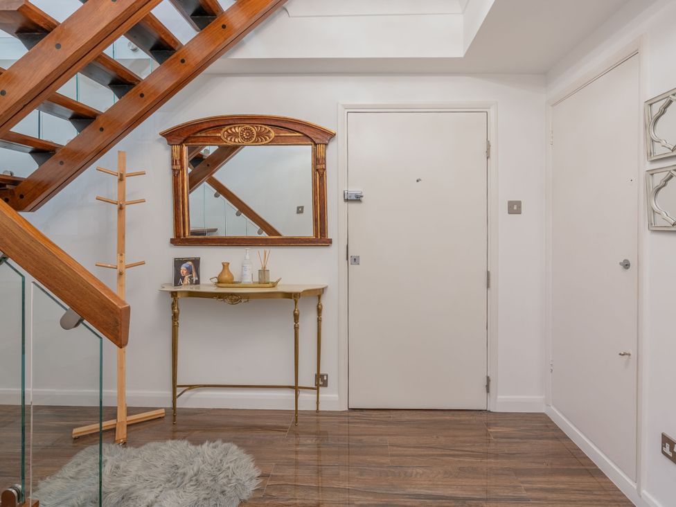 A hallway with a staircase and console table at Beachfront Penthouse in Brighton
