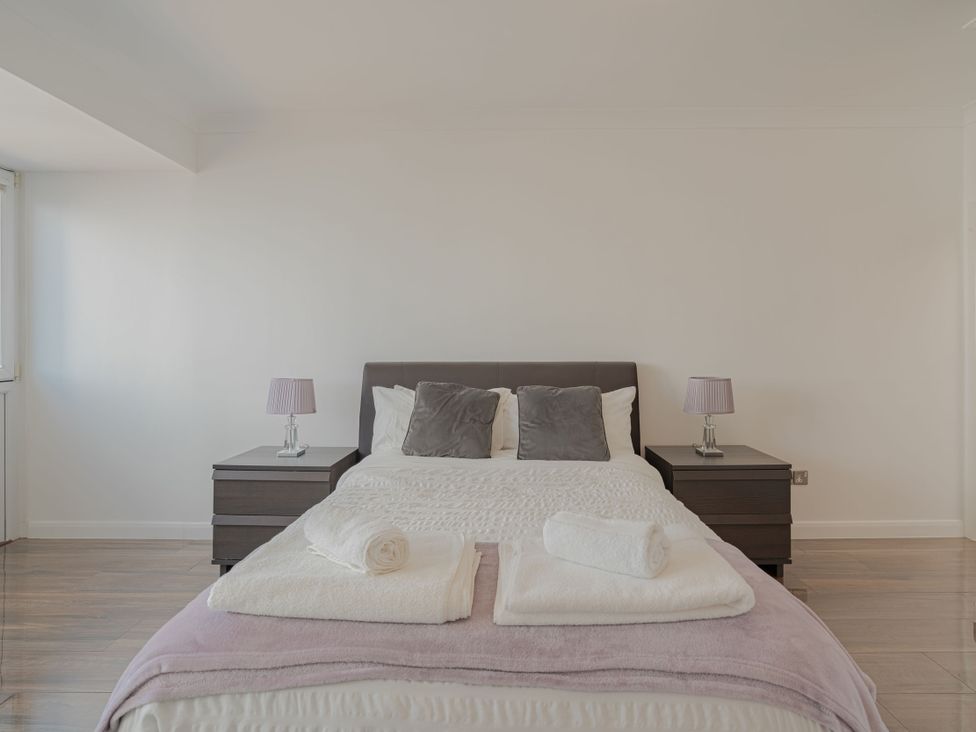 A bedroom with a bed and bedside tables at Beachfront Penthouse in Brighton