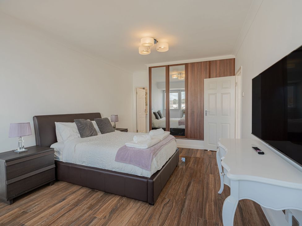 A bedroom with a bed and television at Beachfront Penthouse in Brighton