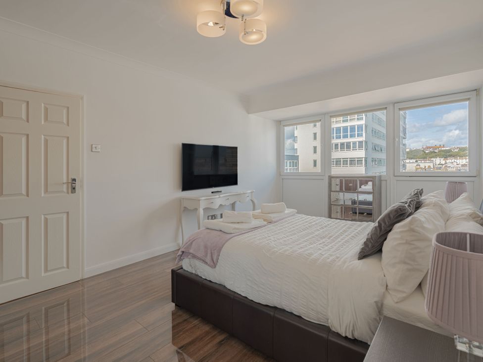 A bedroom with a bed and television at Beachfront Penthouse in Brighton