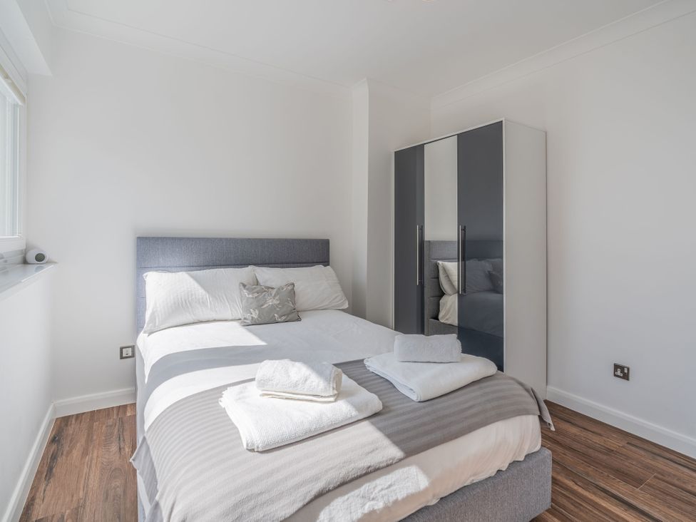A bedroom with a bed and wardrobe at Beachfront Penthouse in Brighton