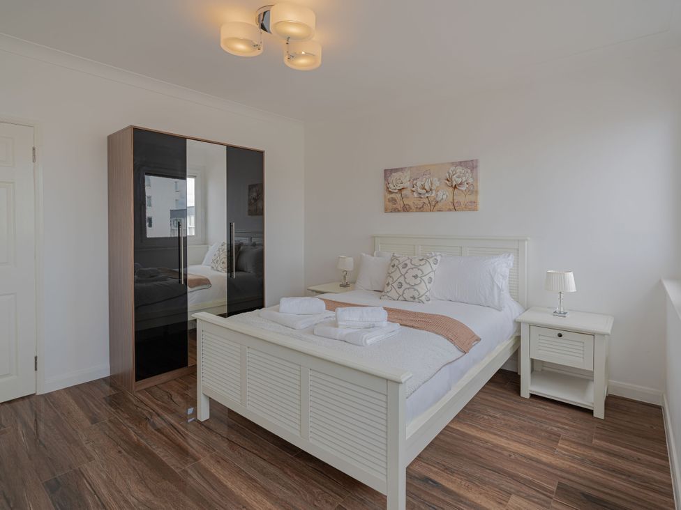 A bedroom with a bed and wardrobe at Beachfront Penthouse in Brighton