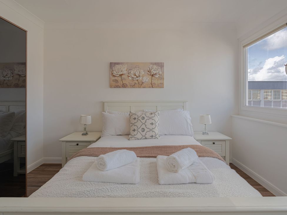A bedroom with a bed and nightstand at Beachfront Penthouse in Brighton