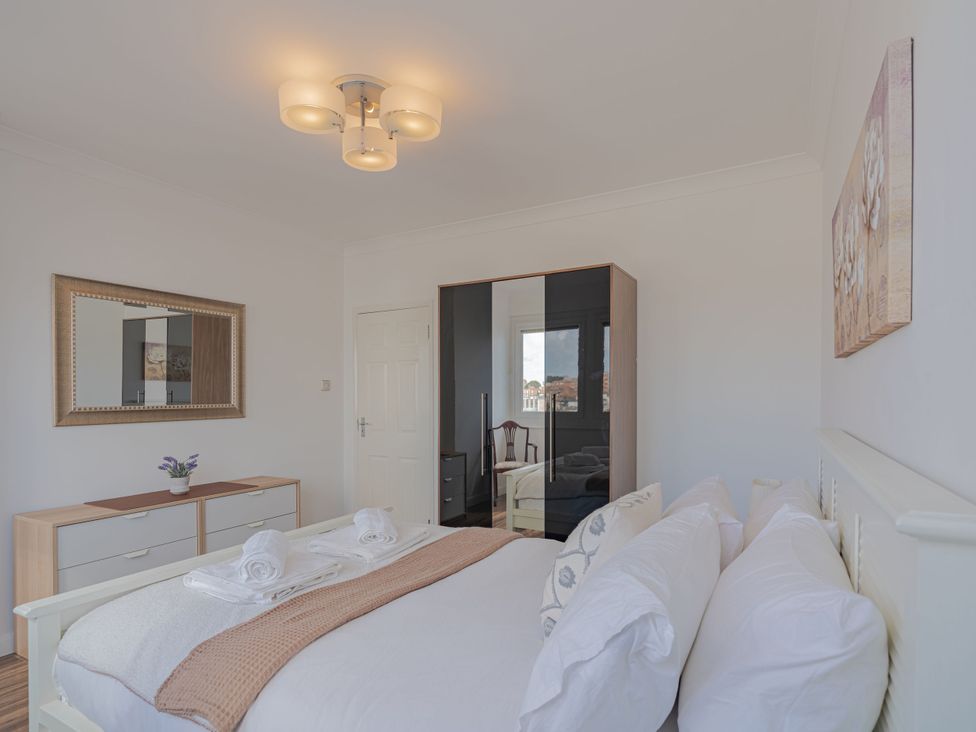 A bedroom with a bed and wardrobe at Beachfront Penthouse in Brighton