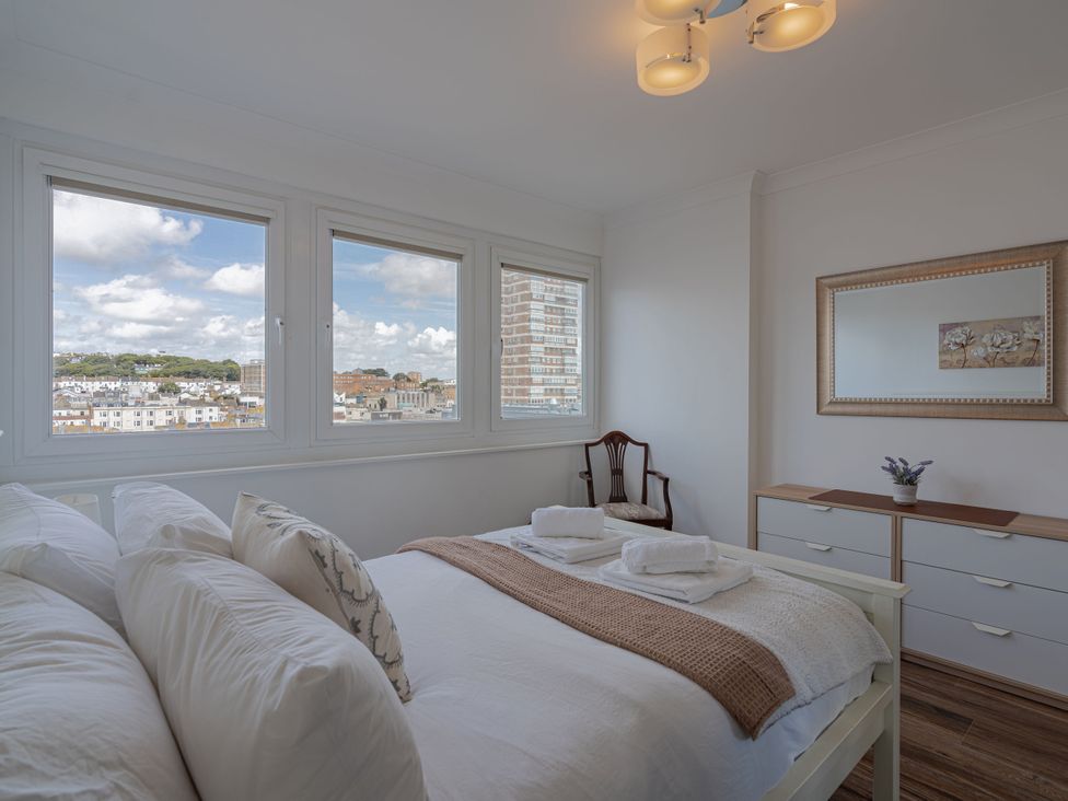 A bedroom with a bed and dresser at Beachfront Penthouse in Brighton