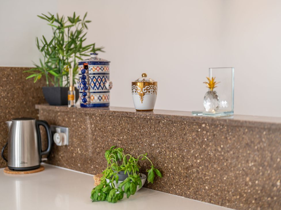 A kitchen countertop with a kettle and decorative items at Beachfront Penthouse in Brighton