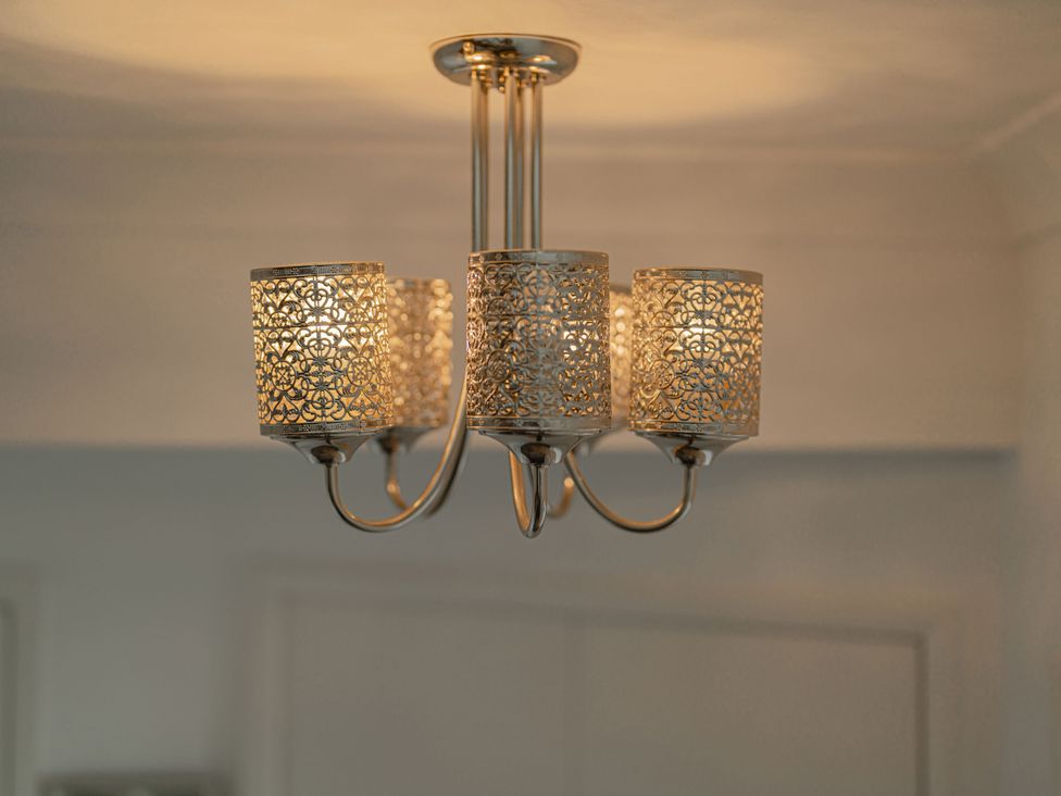 A chandelier with decorative light covers at Beachfront Penthouse in Brighton