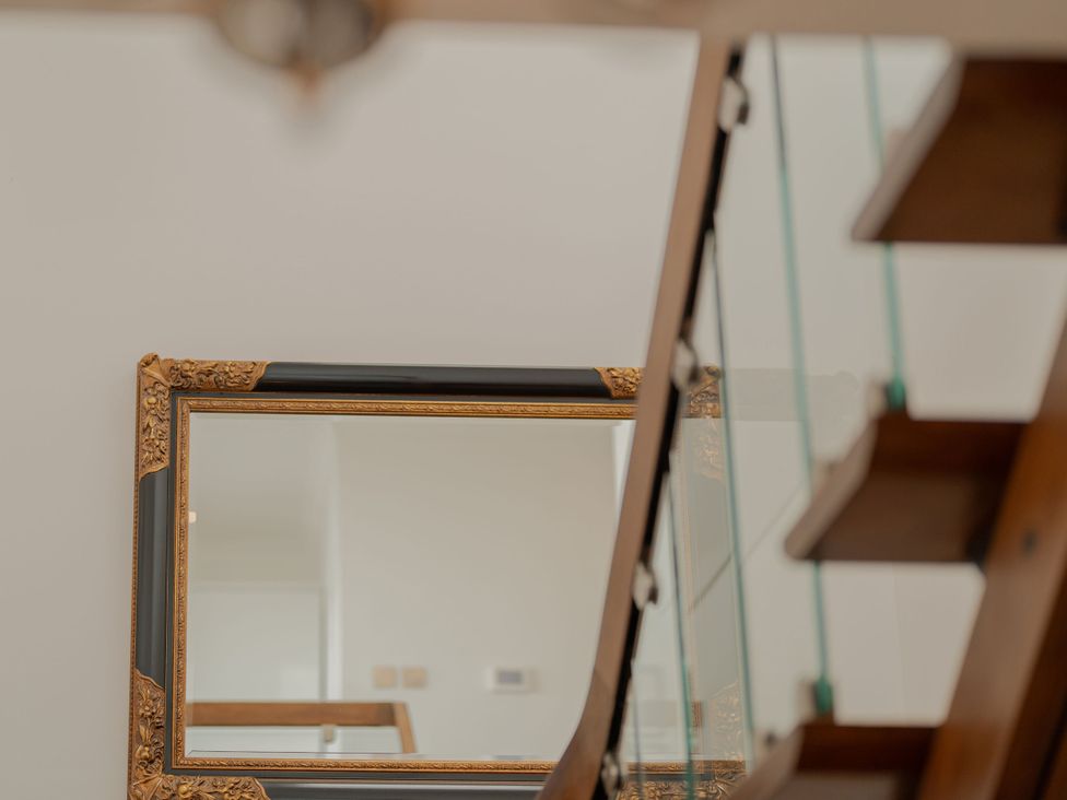 A mirror reflecting the staircase at Beachfront Penthouse Brighton