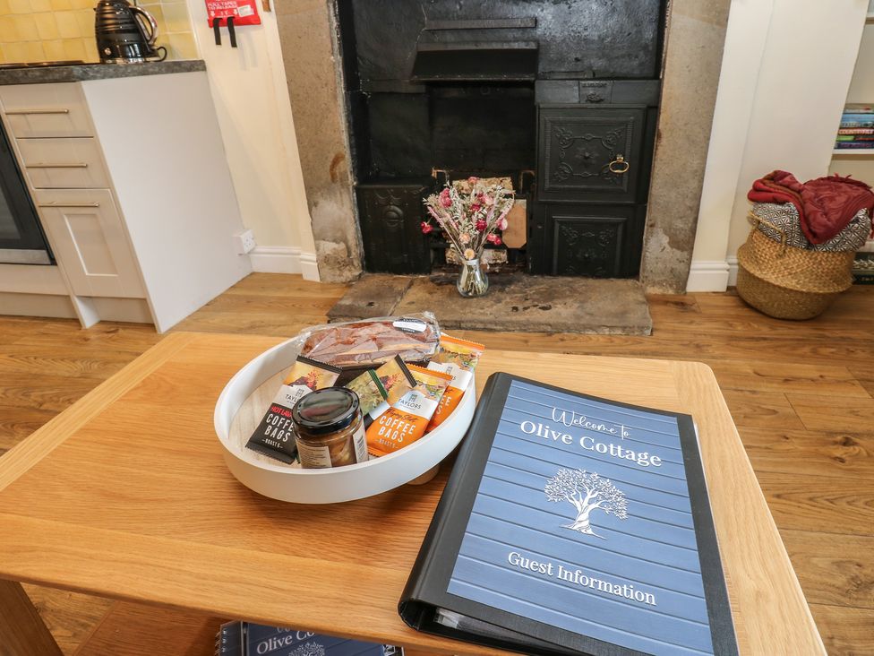 A living room with a coffee tray and guest information book at Olive Cottage in Richmond