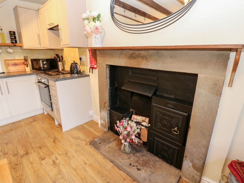 A kitchen with a stove and fireplace at Olive Cottage in Richmond