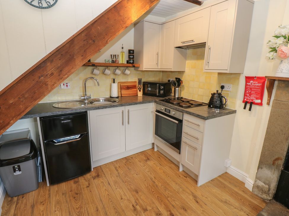 A kitchen with sink and appliances at Olive Cottage in Richmond