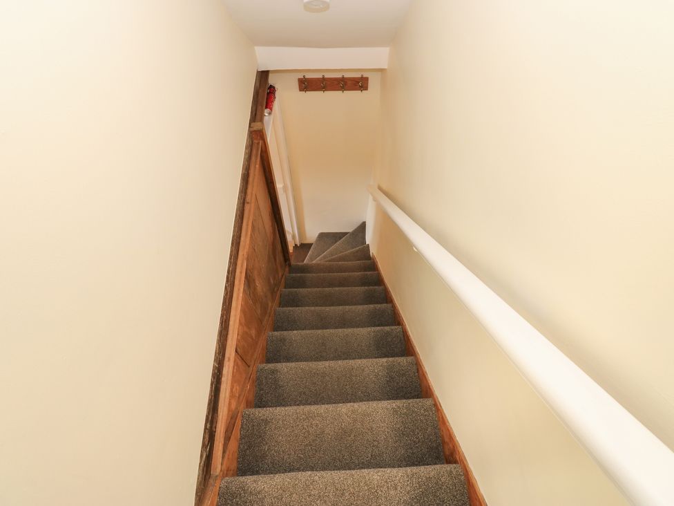 A staircase leading down with a handrail at Olive Cottage in Richmond