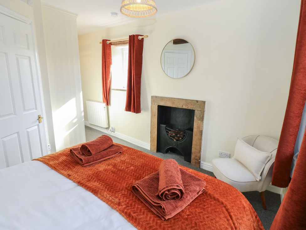 A bedroom with a bed and towels folded on it at Olive Cottage in Richmond