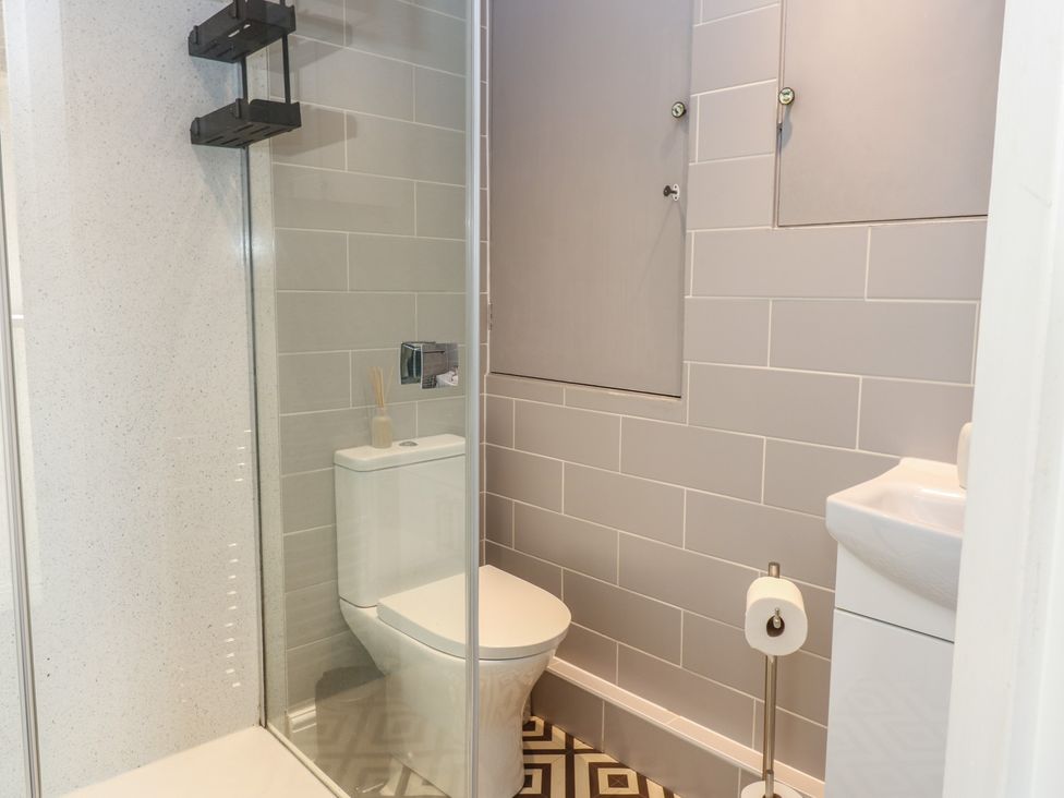 A bathroom with a shower, toilet, and sink at Olive Cottage in Richmond