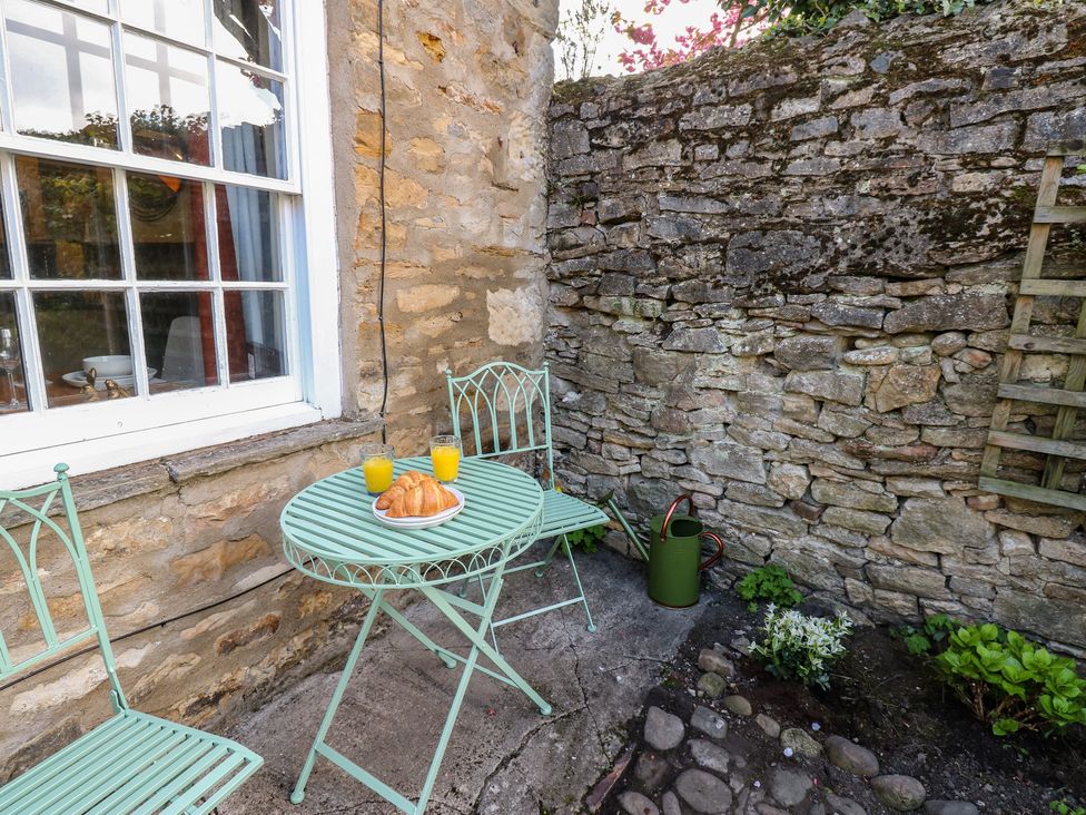 An outdoor seating area with a table and chairs at Olive Cottage in Richmond