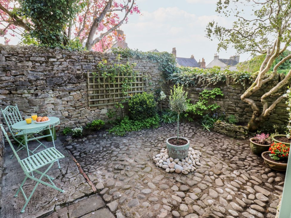 A garden with a table and chairs at Olive Cottage in Richmond