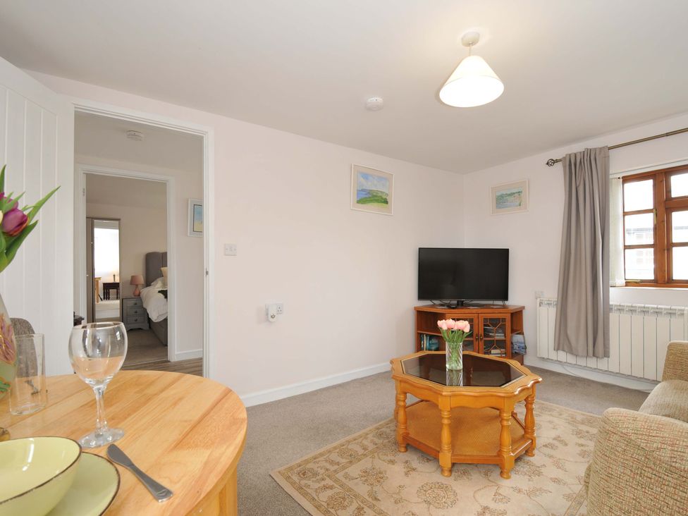 A living room with a television and coffee table at Casa Mia in Porthpean near St Austell