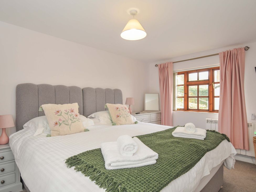 A bedroom with a double bed and a window at Casa Mia in Porthpean near St Austell