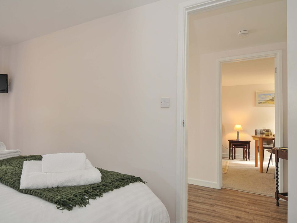 A bedroom with a bed and towels in Casa Mia Porthpean near St Austell