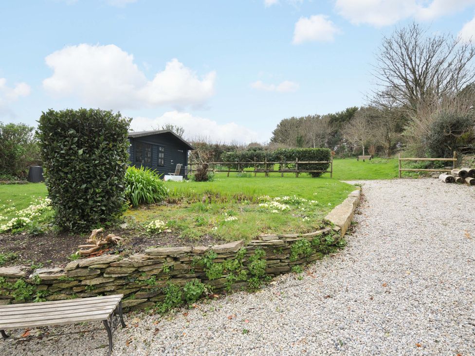 A garden with a shed and gravel path at Casa Mia in Porthpean near St Austell