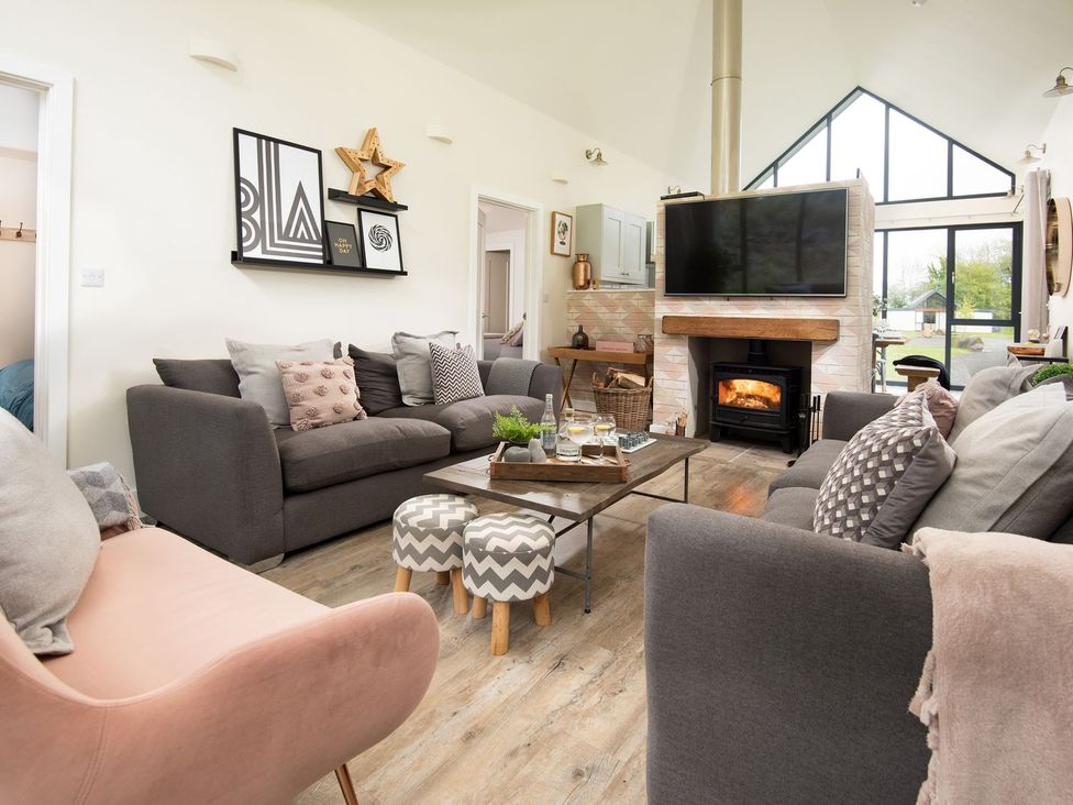 A living room with a fireplace and TV at Summerset Lodge