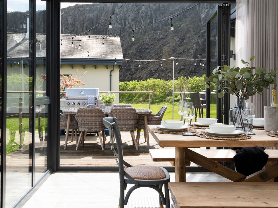 A dining room with a view of the outdoor patio at Summerset Lodge