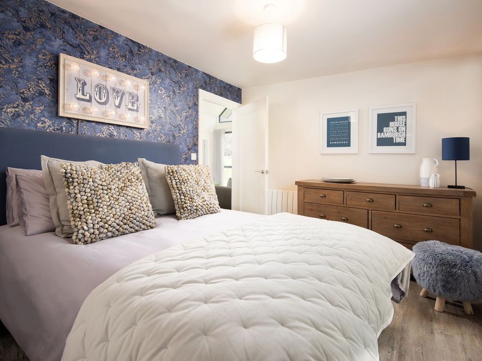 A bedroom with a bed and wall art at Summerset Lodge