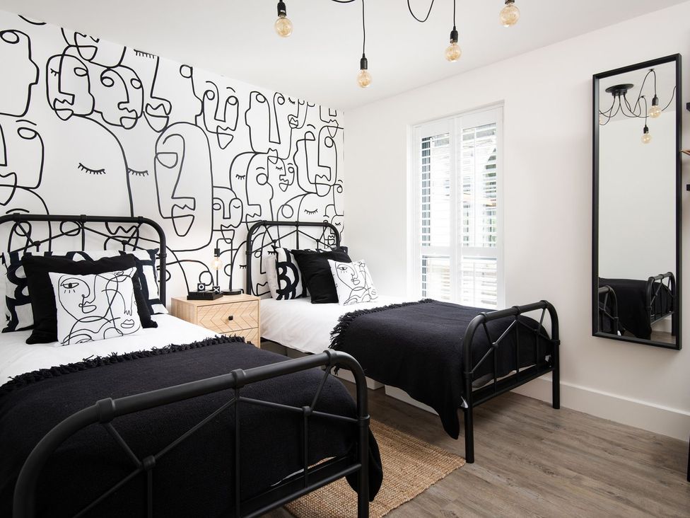 A bedroom with two beds and a mirror at Summerset Lodge