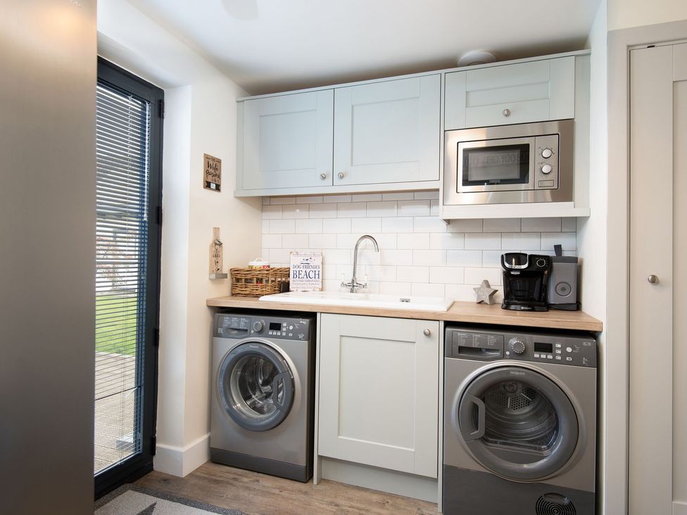 A laundry room with washing machine and sink at Summerset Lodge