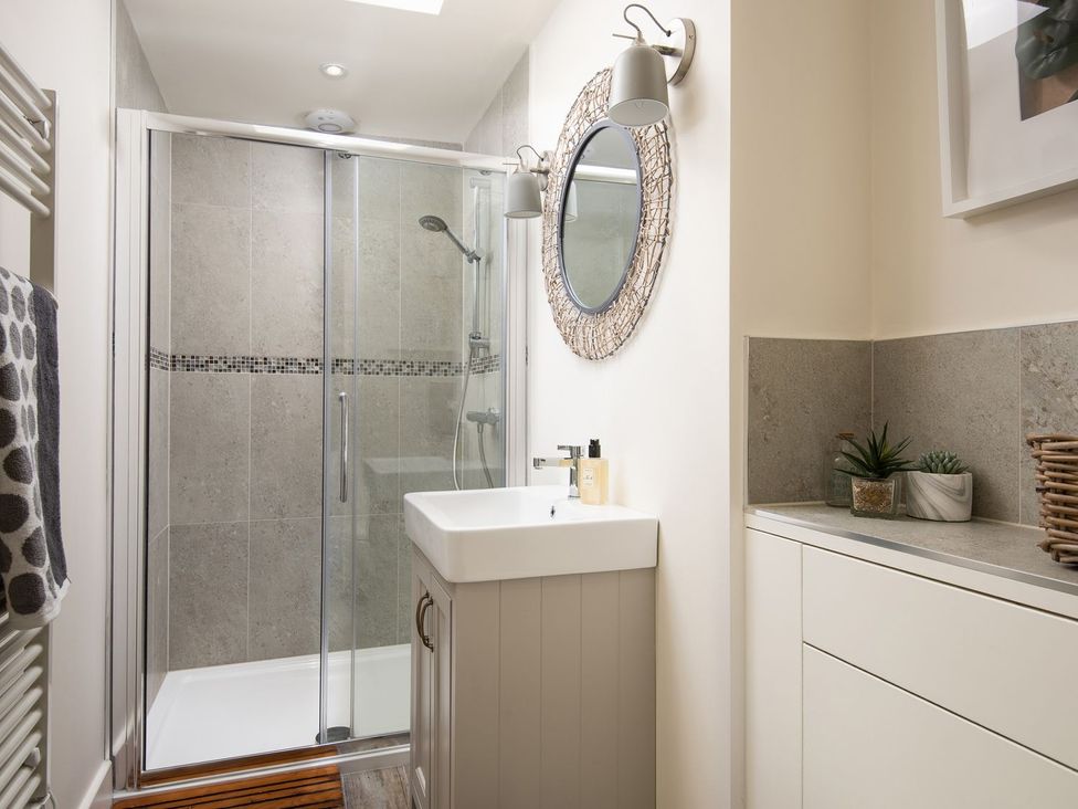 A bathroom with shower, wash basin, and storage at Summerset Lodge
