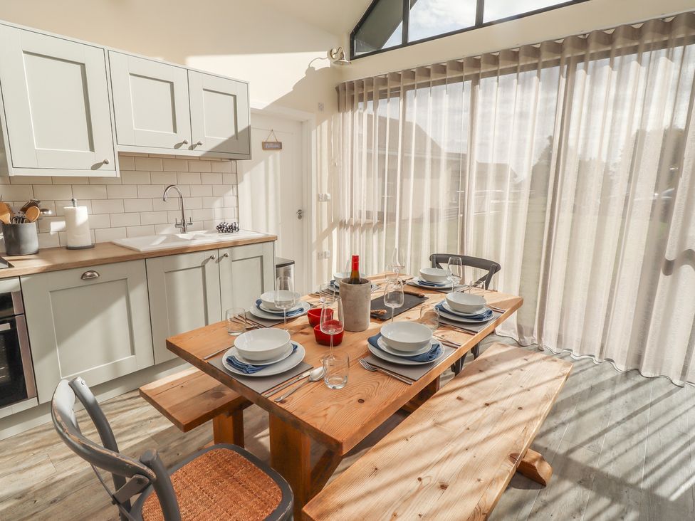 A kitchen with a dining table and chairs at Summerset Lodge in Bamburgh