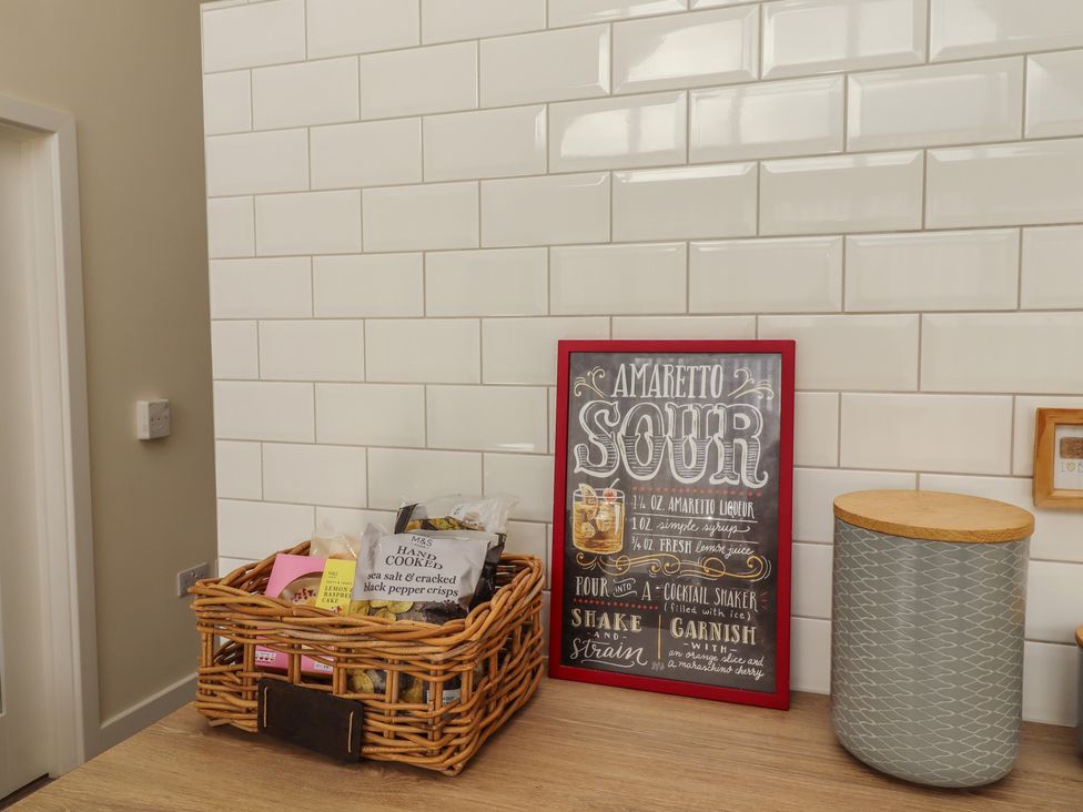 A kitchen with a basket, sign and storage container at Summerset Lodge in Bamburgh