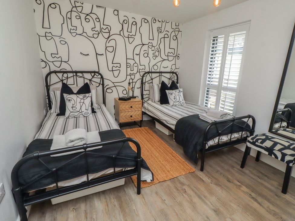 A bedroom with two beds and a nightstand at Summerset Lodge in Bamburgh